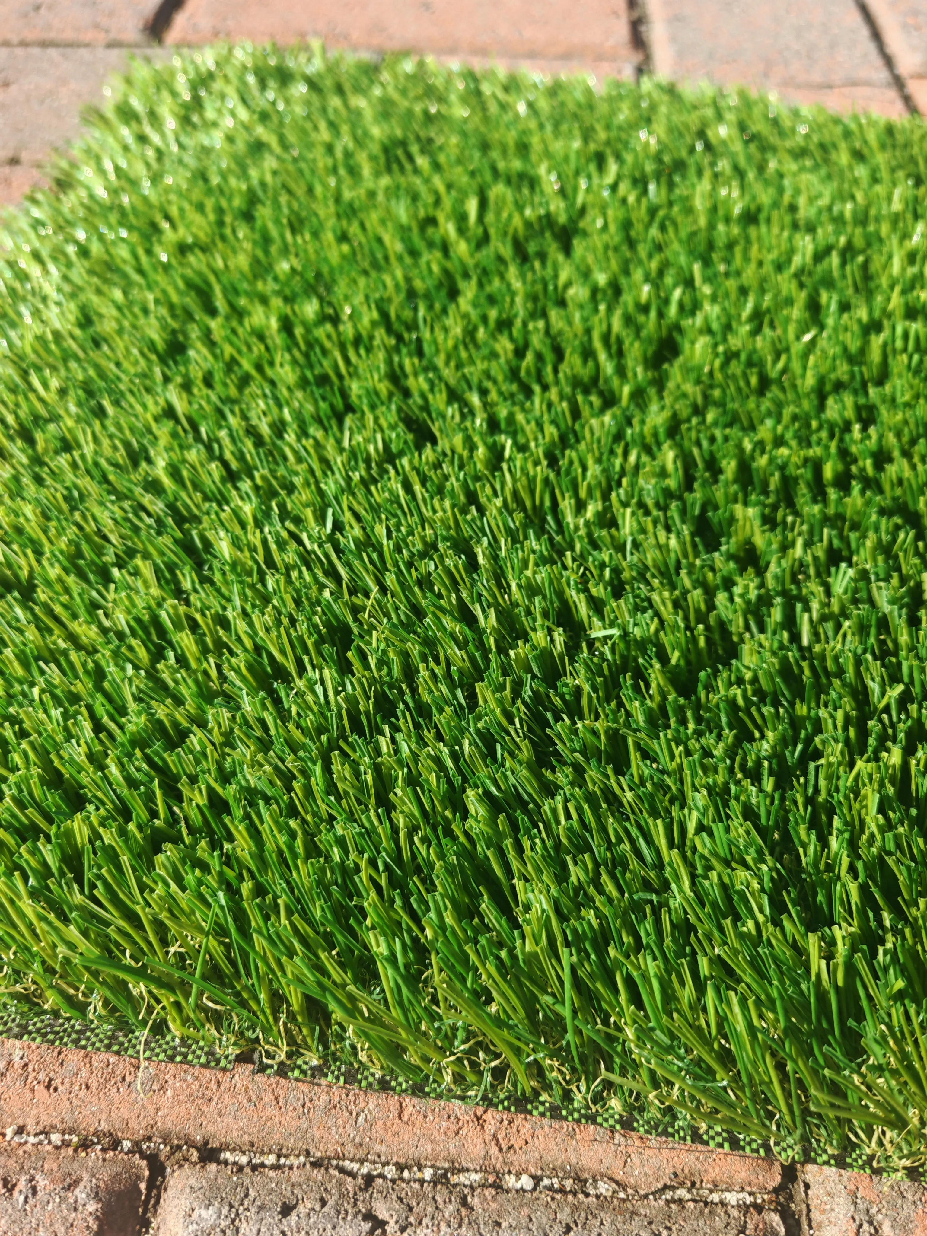40mm C-shape artificial turf sample on brick edging