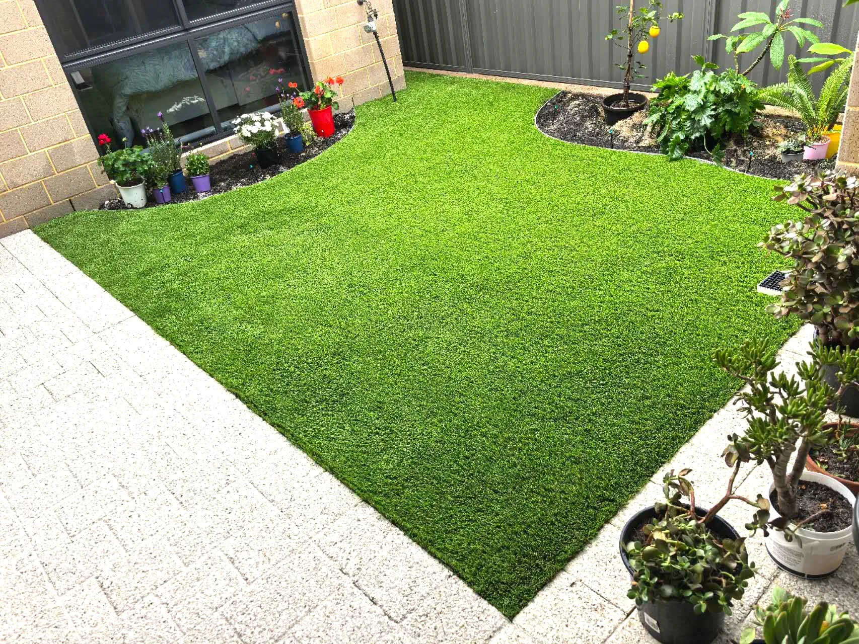 Small finished courtyard with neatly edged artificial turf