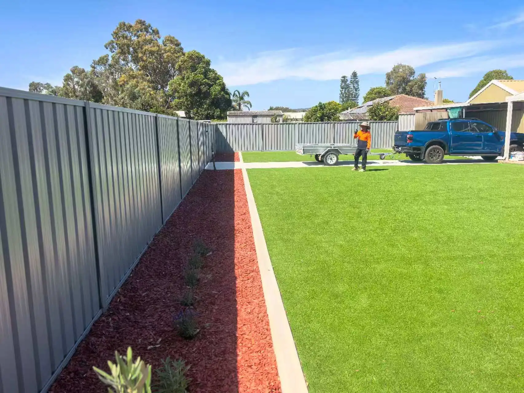 Y&P Dream Yards crew on a finished Perth backyard - artificial grass lawn, Colorbond fence and red-mulched garden bed