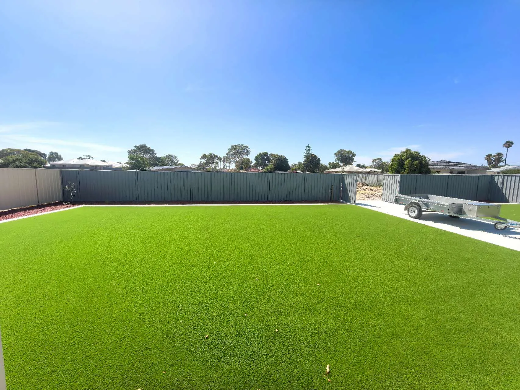 Finished backyard with freshly laid artificial grass